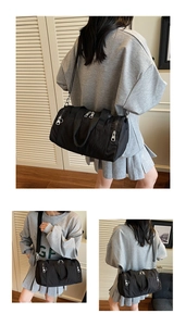 Detail of black large-capacity fitness bag with adjustable strap and multiple zipper pockets