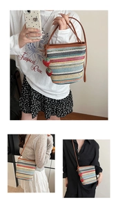 Détails du sac seau tissé avec rayures colorées et breloques fraises rouges