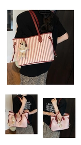 Detail of red and white striped canvas tote bag with leather straps and bear charm