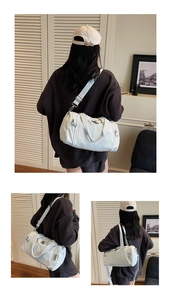 Detailed view of white nylon gym bag with multiple zip pockets and adjustable shoulder strap