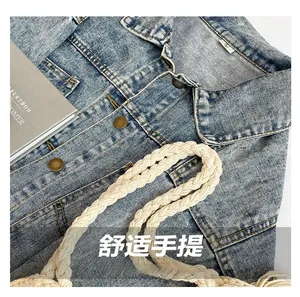 Close-up of light blue washed denim jacket fabric with vintage copper buttons and woven strap