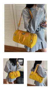 Detail of bright yellow cylindrical nylon travel bag with shoulder strap and dual zippers