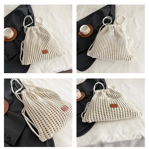 Detail of cream crochet drawstring bag featuring a brown leather patch and woven texture