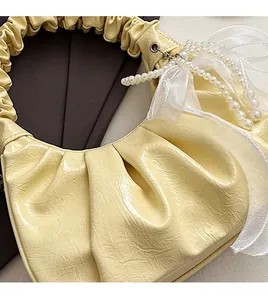 Détail du sac nuage froncé jaune clair avec chaîne en perles et décoration