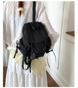 Détails du sac à dos à carreaux noirs et blancs avec rubans décoratifs sur le côté