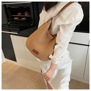 Detail of woven tote bag with leather strap and logo patch in a modern kitchen setting