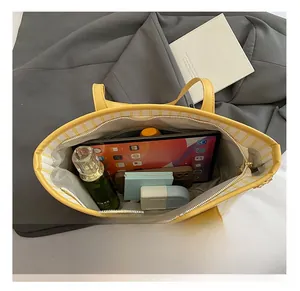 Interior detail of large capacity yellow striped tote bag showing space for tablet and makeup