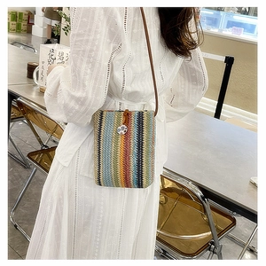 Detailed texture of rainbow straw crossbody bag with colorful woven stripes and strap