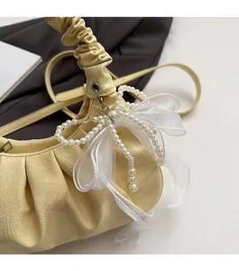 Détail du sac nuage plissé crème avec perles et breloque nœud en organza chic