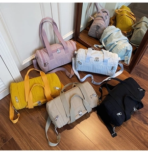 Assorted colors of lightweight nylon gym bags showing side zip pockets and shoulder straps