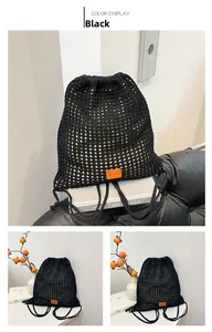 Detail of black woven mesh drawstring backpack with brown leather patch on knit surface