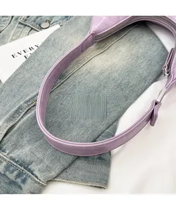 Detail view of purple crocodile pattern bag featuring wide strap and silver metal buckle