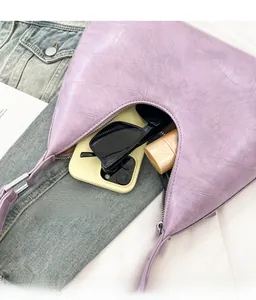 Spacious interior of lavender faux crocodile shoulder bag with phone and sunglasses