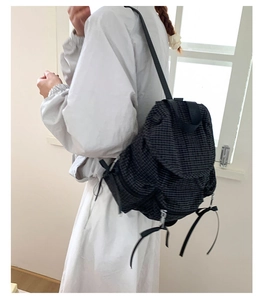 Vue latérale d'une femme portant un sac à dos en nylon noir à carreaux légers