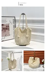 Detail view of white woven straw tote bag with crochet hollow patterns and long tassels