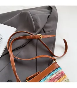 Detail of adjustable brown leather strap and colorful woven stripes on the bucket bag