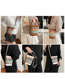 Detail view of colorful rainbow straw bucket bag with strawberry charm for beach vacation