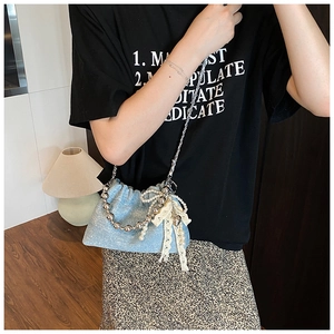 Detail of light blue bucket bag with silver beads, lace bow and pearl charms