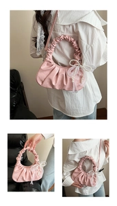 Détail du sac à main plissé rose avec pendentif nœud en perles et nœud en tulle fin