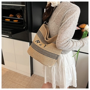 Gros plan du grand sac cabas en paille avec rayures noires et broderie RPY détaillée