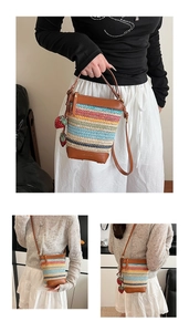 Detail of striped straw bucket bag with leather trim and strawberry charm pendants