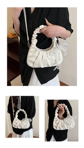 Détail du sac nuage plissé blanc avec nœud en dentelle, perle et texture PU brillante