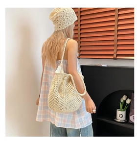 Detail of crochet woven tote bag with fringe tassel and handmade hollow knit texture