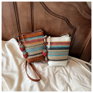 Detail of colorful striped straw bags with strawberry charms and leather trim for beach