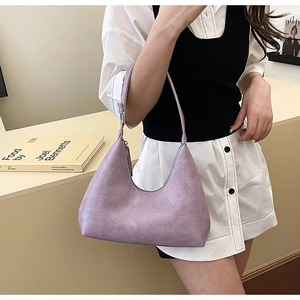 Close-up of lilac crocodile texture leather hobo bag worn by a model in a minimalist setting
