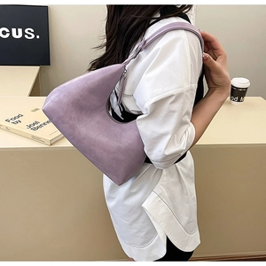Detail of lilac crocodile textured crescent hobo bag shown on model for daily commuting