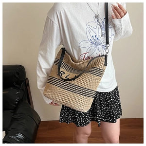 Borsa tote in paglia con ricamo RL nero e spalline in pelle indossata da modella