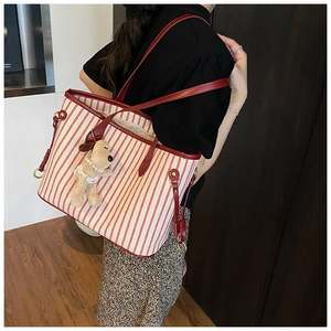 Detail view of red and white striped canvas tote bag with a cute puppy plush pendant