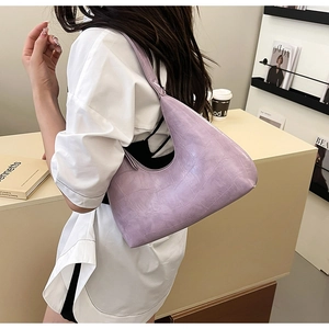 Detail of light purple crocodile pattern hobo bag worn with a white shirt
