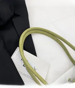 Vue détaillée d'un sac à main vert clair avec texture crocodile et bandoulière large