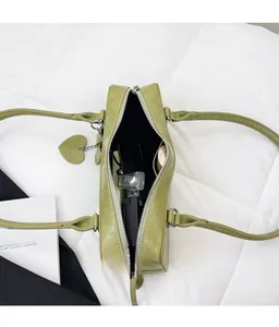 Vue de haut du sac vert à motif crocodile ouvert montrant l'espace de rangement interne