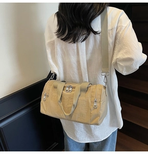 Detail of beige gym bag with multiple zipper pockets and adjustable wide shoulder strap