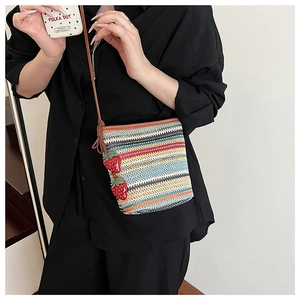 Détail du sac seau tissé coloré avec breloques fraises et fine bandoulière réglable