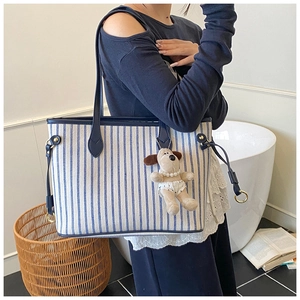 Blue and white striped canvas tote bag with dark blue leather handles and plush dog charm