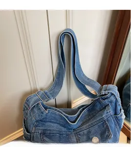 Detail of adjustable denim wide shoulder strap with silver buckle on crossbody bag