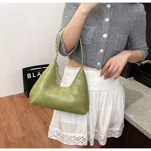 Detail of light green crocodile pattern hobo bag with adjustable shoulder strap buckle