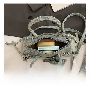 Detail of light blue denim Boston bag showing internal capacity and zip closure