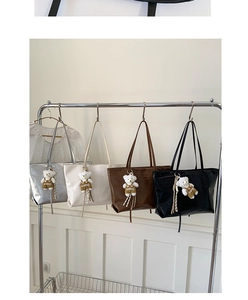 Detail of four faux leather tote bags in silver, white, brown and black with croc texture