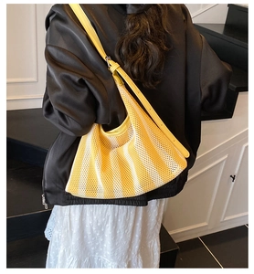 Détail du sac cabas en maille rayée jaune avec bandoulière en cuir et boucle argentée