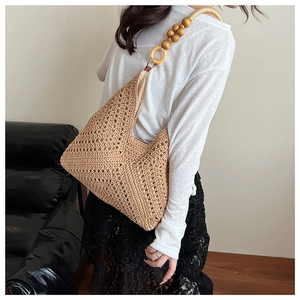Detailed close-up of beige crochet shoulder bag with artistic wooden bead strap design