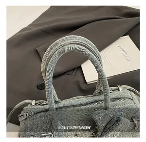 Detail of reinforced light blue denim handle with silver studs and metal zipper