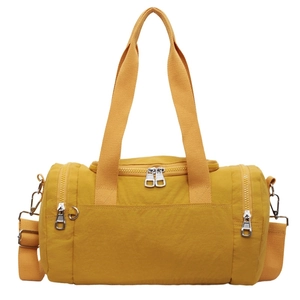 Minimalist ginger yellow nylon cylinder duffel bag with adjustable shoulder straps