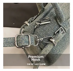 Detail of silver hardware hooks and zipper on light blue washed denim bag