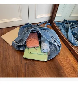 Spacious interior of denim tote bag showing tablet, umbrella, and wallet storage