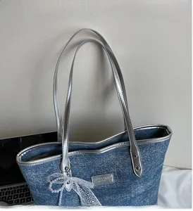 Dettaglio borsa tote in denim glitterato con manici in pelle argento e fiocco di perle
