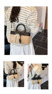 Detail of woven straw tote bag with black leather trim and pearl lace bow accessory
